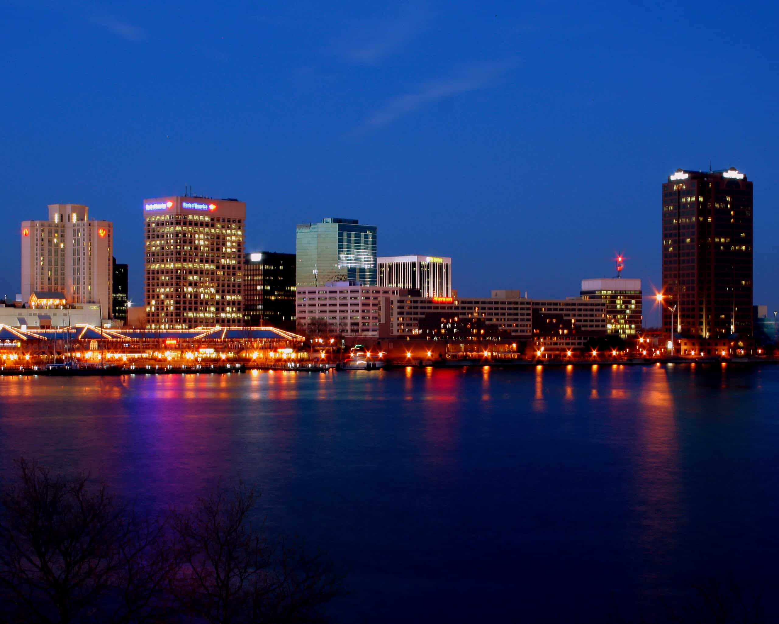 Downtown Norfolk Virginia skyline at night with city lights reflected on water